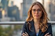 © Danko - Portrait of a young happy pretty smiling professional business woman, happy confident positive female entrepreneur standing outdoor on street arms crossed