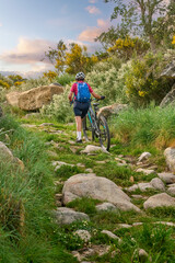 Wall Mural - active senior woman cycling with her electric mountain bike in the rough landscape of National Parc Serra de São Mamede near Marvao in central Portugal, Europe
