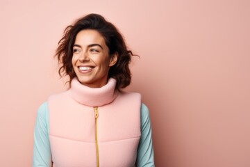 Wall Mural - Portrait of a joyful woman in her 30s dressed in a thermal insulation vest in pastel or soft colors background