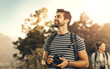 © peopleimages.com - Outdoor, nature and man with camera, adventure and thinking with sunshine, freedom and memory. People in forest, woman and guy with journey, photography and getaway trip with research and equipment