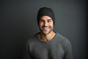 Poster - Portrait of a grinning man in his 30s donning a warm wool beanie in front of minimalist or empty room background