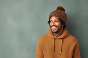 Wall Mural - Portrait of a blissful afro-american man in his 30s donning a warm wool beanie in front of minimalist or empty room background