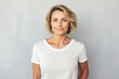 © CogniLens - Portrait of a blissful woman in her 40s dressed in a casual t-shirt isolated in minimalist or empty room background