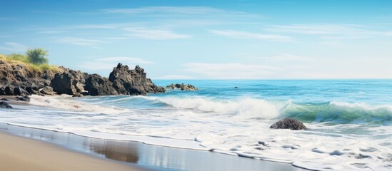 Leinwandbilder - Remote beach calm sea with volcanic rocky shores with small waves on the water surface The summer ocean beach a holiday vacation and travel concept with a focus on natural scenery Nobody