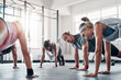 © DoneDeal/peopleimages.com - Team, fitness class and exercise with push ups in gym for arm strength, healthy body and core workout. Training collaboration, people and muscle challenge for abs, weightloss and physical activity