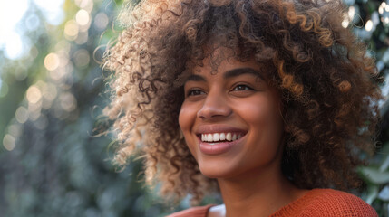 Wall Mural - Portrait of happy young woman with curly hair outdoors