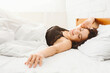 © Prostock-studio - Young well-slept woman waking up in her bed, smiling and stretching, empty space