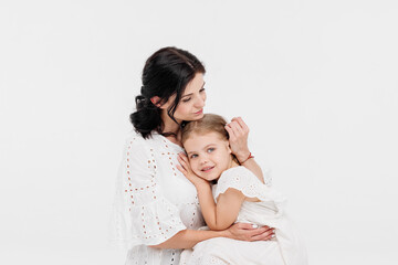 Close-up of a touching and gentle mother and daughter on a light background. Mom's tender touch. Family concept.