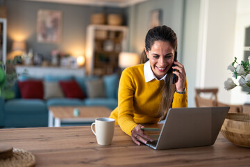 Wall Mural - Happy satisfied businesswoman using modern smartphone in her home office at early morning about to make a deal via cell phone while sitting at her working space.