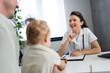 © lordn - A woman pediatrician is examining her little girl patient and talking with her father