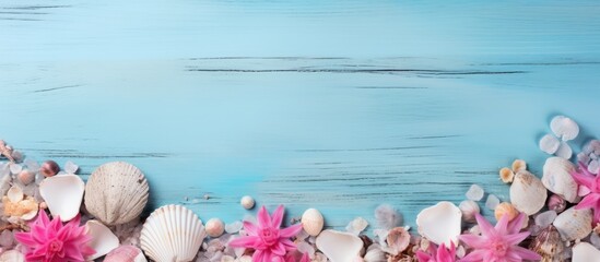 Wall Mural - Seashell on wooden blue background abstract with pink flowers sea stones concept. Creative banner. Copyspace image