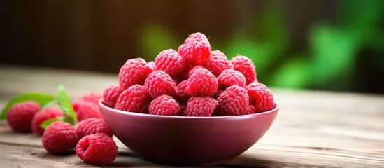 Wall Mural - ripe raspberries in a bowl on old wooden table with a blurred background. Creative banner. Copyspace image