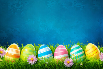 Colorful easter eggs in green grass against a blue background