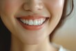 © tonstock - Bright, healthy smile of a young woman showcasing perfectly aligned white teeth, close-up detail highlighting oral care and dental aesthetics.