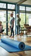 © LukaszDesign - Senior couple, rolling yoga mat, indoor training, living room floor fitness. In the lounge, seniors practice pilates, live healthy, and balance their bodies.