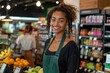 © Pinklife - A happy female grocery store attendant poses, with a friendly and welcoming demeanor at her workstation