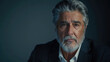© sommersby - A close-up portrait of a senior man with gray hair and a beard. He is looking directly at the camera with a serious expression