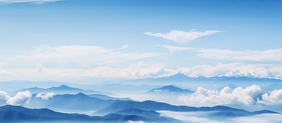 Wall Mural - Clouds falling on mountains in blue sky background. Creative banner. Copyspace image