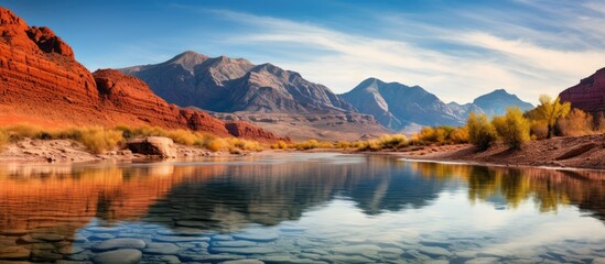 Poster - Mountain scenery behind calm water and red rocks. Creative banner. Copyspace image