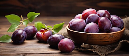 Wall Mural - Bowl of freshly picked Italian plums on a rustic wooden table. Creative banner. Copyspace image