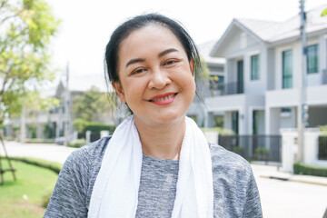 Happy Asian runner woman smile looking at camera in neighborhood. healthy lifestyle to prevent sickness and getting stronger.