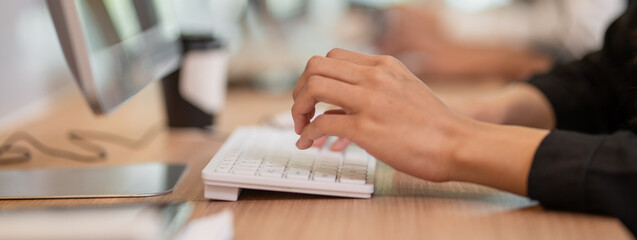 Closeup business people hands typing on computer keyboard for using internet, searching data, working, writing email in the office