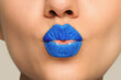 © New Africa - Woman with light blue lipstick sending air kiss, closeup view