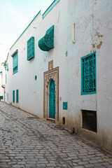 Traditional blue Tunisian metal door with a pattern in a white building in the city of Sidi Bou Said in Tunisia in the summer on a sunny day