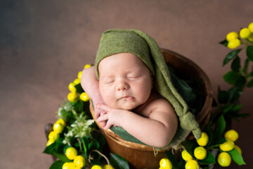 Wall Mural - child in a wooden basket with yellow lemons