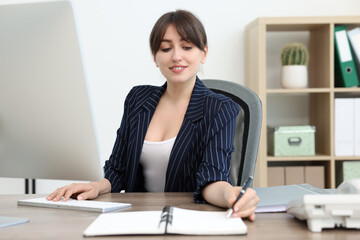 Canvas Print - Smiling secretary working at table in office