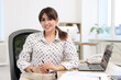 © New Africa - Portrait of smiling secretary at table in office