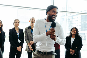 Wall Mural - lively corporate conference with happy businessman speaking to enthusiastic team
