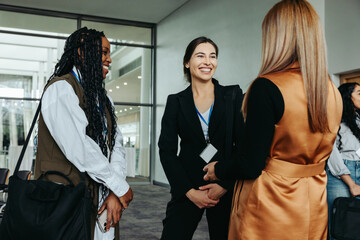 Wall Mural - networking businesswomen smiling and talking at professional conference