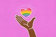 © ADDICTIVE STOCK - Hand holding a vibrant rainbow heart illustration for Pride Day