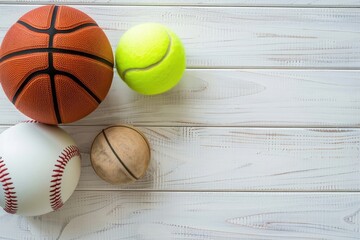 Wall Mural - Photo of a basketball, baseball, and tennis ball on a white wooden background with copy space for text in a top view. Flat lay style stock photo