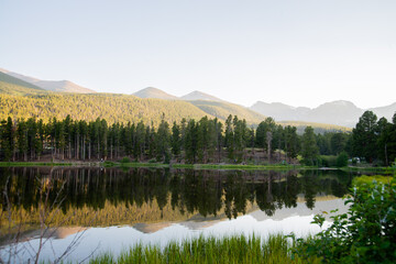 forest and mountains reflected in a lake