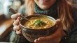 © Artyom - Woman enjoying bowl of hot soup