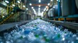 © kept - Conveyor belt with crushed plastic bottles in a recycling plant.