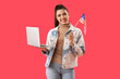 © Pixel-Shot - Young woman with USA flag and laptop on red background