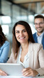© StirfryMoJi - A happy businesswoman holding a tablet and smiling during a meeting at the office.