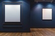 © JM - A modern art gallery with two empty, blank picture frames on a dark blue wall, wooden floor, and soft overhead lighting. The larger frame is slightly to the left and smaller one to the right.