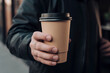 © Nitcharee - man holding paper coffee cup outdoors with space for a text
