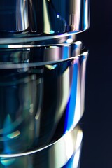 wallpaper of macro photo of clean polished glass and silver metall, edges with light from four different colors, depth of field, blurred, dark navy and dark azure, dark background, natural colors, 2:3