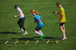 © master1305 - Athletic Training on Field Kids wearing sports gear engaged in challenging footwork exercise with agility ladder equipment. Concept of sport, school, childhood, hobby, active lifestyle