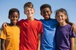 © hakule - A group of four children are smiling and wearing colorful t-shirts