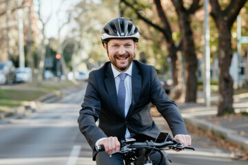 A cheerful businessman in a suit and helmet rides an electric bike on a sunny day, epitomizing modern, eco-friendly commuting.