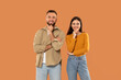 © Prostock-studio - A man and a woman are standing side by side, looking towards the camera. They appear to be in a casual setting, with neutral expressions on their faces.