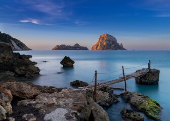 Sticker - small wooden pier in Cala d'Hort with a view of the Es Vedra rocks in the background at sunrise