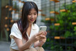© Phimwilai - Modern smiling woman uses her phone to play online. Check finances via online banking Talk through the application Online communication, business ideas, learning.