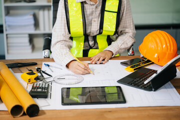 Wall Mural - businessman hand working and laptop with on on architectural project at construction site